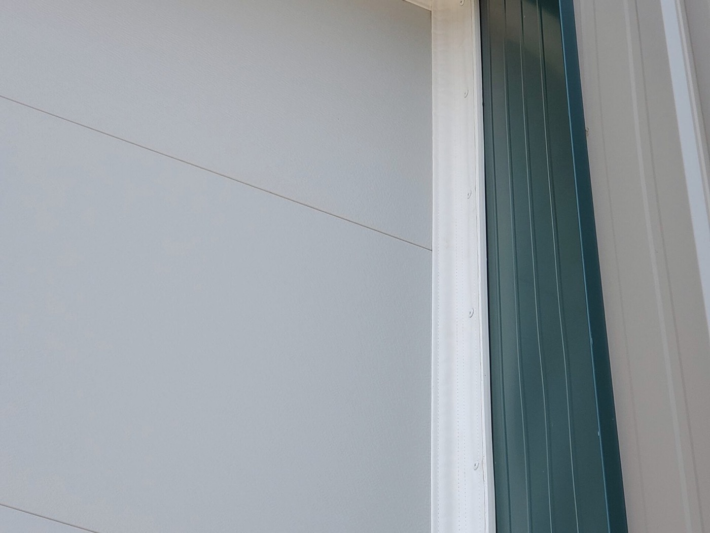 Torn garage door weather stripping seal creating gaps near the floor