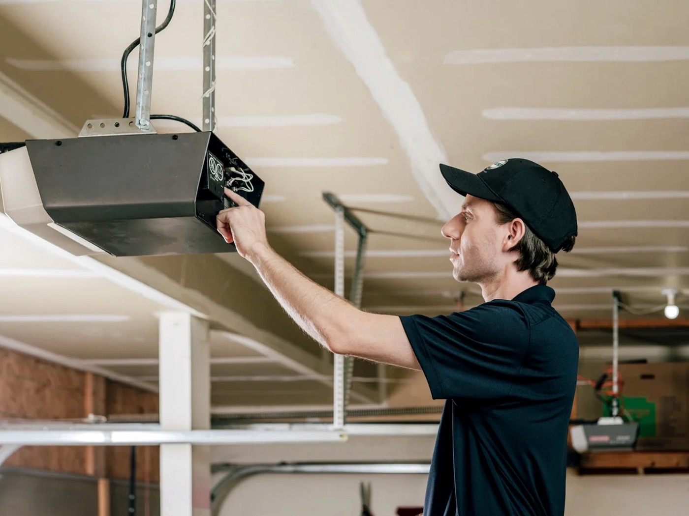 Technician repairing a residential garage door opener motor